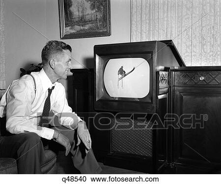 Stock Image - 1940S 1950S Smiling Man At Home Watching Sports Program On Television. Fotosearch