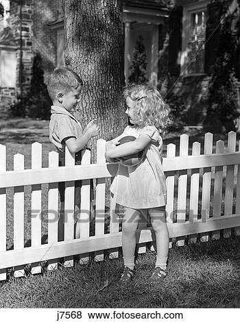 1940S Boy Girl Holding Ball Talking Flirting Over White Picket Fence Neighbors View Large Photo Image Stock Photo - 1940S Boy Girl Holding Ball Talking Flirting Over White Picket Fence Neighbors. Fotosearch