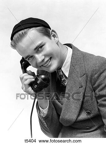 Picture - 1940S College Age Man In Suit And Freshman Dink Hat Smiling Talking On Telephone Looking At Camera . Fotosearch