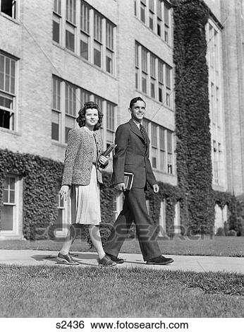 Stock Photograph - 1940S College Couple Walking On Campus Before Ivy Covered Building. Fotosearch