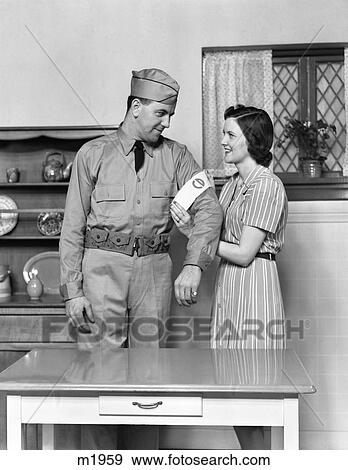 1940S Couple Man Woman Wife Helping Husband Put On Civil Defense Uniform View Large Photo Image Stock Photo - 1940S Couple Man Woman Wife Helping Husband Put On Civil Defense Uniform. Fotosearch