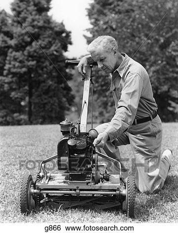 1940S Elderly Man In Yard Kneeling Down To Fix Lawnmower View Large Photo Image Stock Photograph - 1940S Elderly Man In Yard Kneeling Down To Fix Lawnmower. Fotosearch