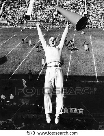 1940S Male Cheerleader With Megaphone Jumping In Air At Football Game View Large Photo Image Stock Image - 1940S Male Cheerleader With Megaphone Jumping In Air At Football Game. Fotosearch