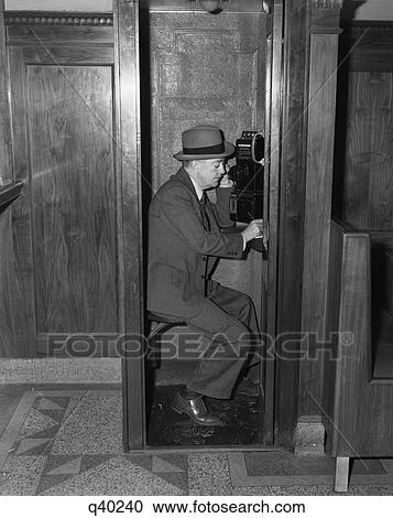 1940S Man Sitting In Wooden Telephone Booth Speaking Into Receiver View Large Photo Image Stock Image - 1940S Man Sitting In Wooden Telephone Booth Speaking Into Receiver. Fotosearch