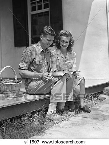 1940S Man Woman Sitting On Porch Of Farmhouse Reading Catalog View Large Photo Image Stock Photo - 1940S Man Woman Sitting On Porch Of Farmhouse Reading Catalog. Fotosearch