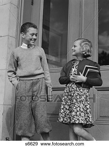 1940S Smiling Boy & Girl Holding School Books By Doors View Large Photo Image Stock Photo - 1940S Smiling Boy & Girl Holding School Books By Doors. Fotosearch