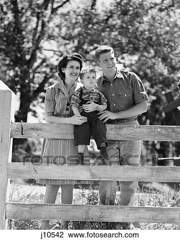 1940S Smiling Happy Family Mother Father Toddler Boy Portrait By Farm Fence View Large Photo Image Stock Image - 1940S Smiling Happy Family Mother Father Toddler Boy Portrait By Farm Fence. Fotosearch