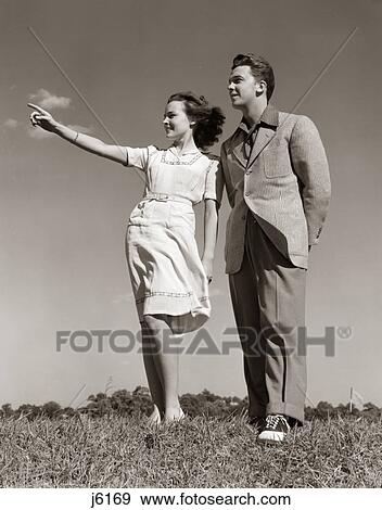 1940S Teenage Couple Standing Together Outdoors Girl Pointing View Large Photo Image Stock Photo - 1940S Teenage Couple Standing Together Outdoors Girl Pointing. Fotosearch