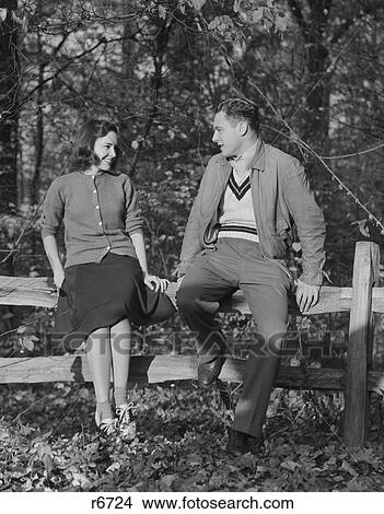 1940S Young Couple Sitting On Fence Autumn Smiling At One Another View Large Photo Image Picture - 1940S Young Couple Sitting On Fence Autumn Smiling At One Another. Fotosearch