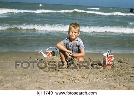 Stock Photo - 1950S 1954 Little Boy Playing In The Sand At Beach. Fotosearch