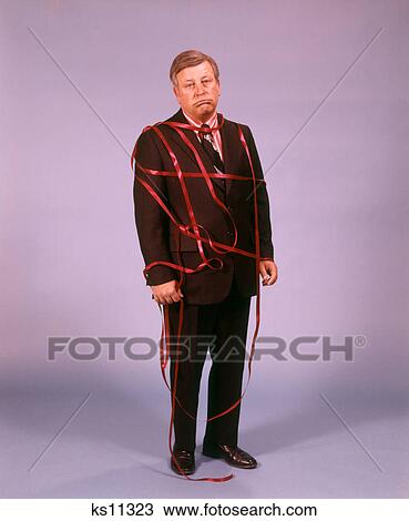 1950S 1960S 1970S Middle Aged Man Wearing Business Suit Disappointed Depressed Unhappy Expression Tied Up In Red Tape View Large Photo Image Stock Image - 1950S 1960S 1970S Middle Aged Man Wearing Business Suit Disappointed Depressed Unhappy Expression Tied Up In Red Tape . Fotosearch