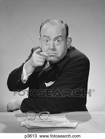 Stock Image - 1950S 1960S Angry Businessman Pointing Finger Bulging Staring Eyes Wide Open . Fotosearch
