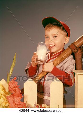 Picture - 1950S 1960S Boy Drinking Milk Wearing Baseball Uniform By Picket Fence. Fotosearch