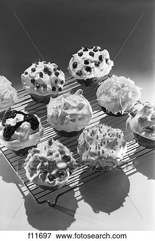 1950S 1960S Cupcakes On Metal Bakers Cooling Rack Decorated With Icing Sprinkles Chips View Large Photo Image Stock Photo - 1950S 1960S Cupcakes On Metal Bakers Cooling Rack Decorated With Icing Sprinkles Chips. Fotosearch