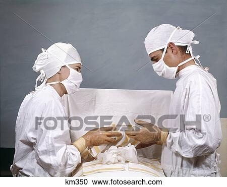 1950S 1960S Doctor & Nurse In Surgery Operation Operating Sterile Surgical White Caps Gowns Masks View Large Photo Image Stock Image - 1950S 1960S Doctor & Nurse In Surgery Operation Operating Sterile Surgical White Caps Gowns Masks . Fotosearch