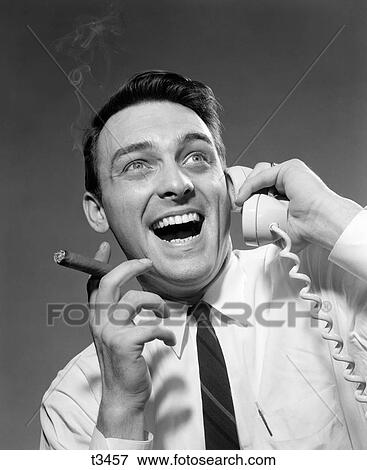 1950S 1960S Excited Man Talking On Telephone Grinning Smoking Cigar Indoor View Large Photo Image Stock Photo - 1950S 1960S Excited Man Talking On Telephone Grinning Smoking Cigar Indoor. Fotosearch