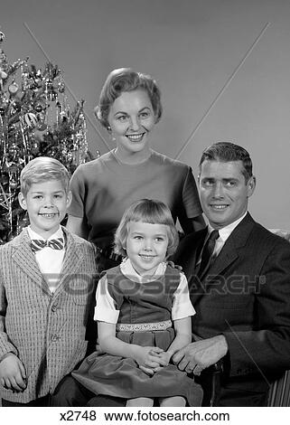 1950S 1960S Family Portrait Smiling Father Mother Daughter Son Sitting Together In Front Of Indoor Christmas Tree View Large Photo Image Stock Photo - 1950S 1960S Family Portrait Smiling Father Mother Daughter Son Sitting Together In Front Of Indoor Christmas Tree. Fotosearch