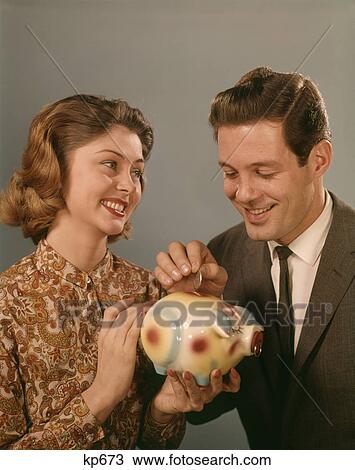 1950S 1960S Happy Smiling Couple Man Woman Putting Coins Into Savings Piggy Bank View Large Photo Image Stock Image - 1950S 1960S Happy Smiling Couple Man Woman Putting Coins Into Savings Piggy Bank . Fotosearch