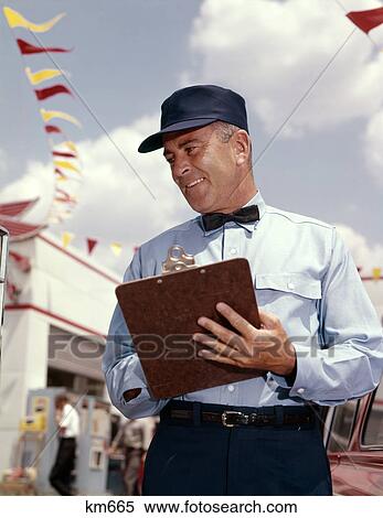 Stock Photography - 1950S 1960S Man Service Manager At Automobile Gas And Repair Service Station Writing On Clipboard. Fotosearch