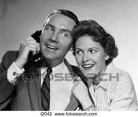 1950S 1960S Man Talking On Telephone Woman Leaning In To Listen Indoor View Large Photo Image Stock Image - 1950S 1960S Man Talking On Telephone Woman Leaning In To Listen Indoor. Fotosearch