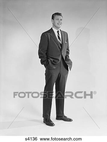 1950S 1960S Portrait Smiling Man Standing With Hands In Pockets Wearing Suit And Tie View Large Photo Image Stock Photograph - 1950S 1960S Portrait Smiling Man Standing With Hands In Pockets Wearing Suit And Tie. Fotosearch