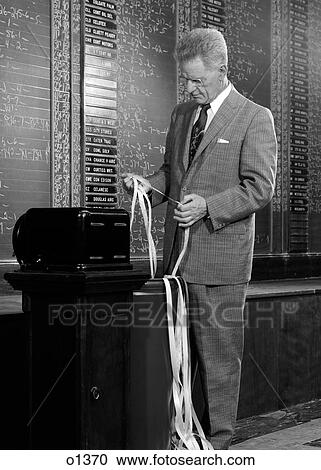 1950S 1960S Serious Businessman Stock Broker Reading Quotation Tape At Office Ticker-Tape Machine On Exchange Indoor View Large Photo Image Stock Image - 1950S 1960S Serious Businessman Stock Broker Reading Quotation Tape At Office Ticker-Tape Machine On Exchange Indoor. Fotosearch