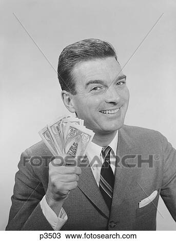 Stock Image - 1950S 1960S Smiling Man Holding A Fistful Of Money Fake Bills Looking At Camera. Fotosearch