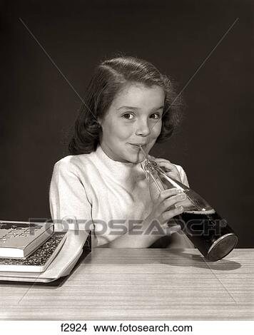 1950S 1960S Smiling School Girl Using Straw Drinking Carbonated Beverage From Bottle View Large Photo Image Picture - 1950S 1960S Smiling School Girl Using Straw Drinking Carbonated Beverage From Bottle. Fotosearch