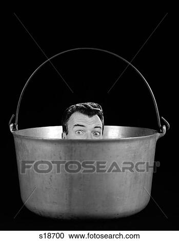 Stock Image - 1950S 1960S Symbolic Montage Portrait Man In The Soup Looking Wide Eyed From Inside The Kettle. Fotosearch