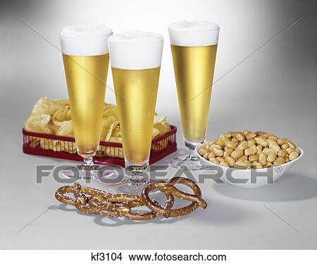 Picture - 1950S 1960S Three Pilsner Glasses Of Beer Pretzels Peanuts Potato Chips. Fotosearch
