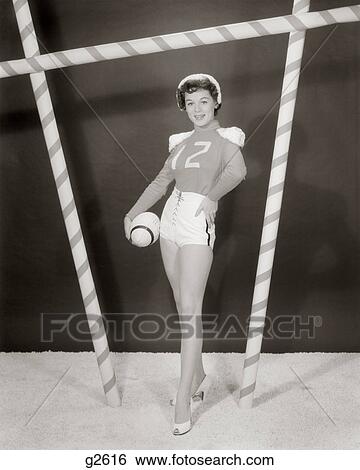 Stock Photograph - 1950S 1960S Woman In Sexy Football Costume At Goalpost. Fotosearch
