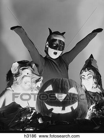 1950S 3 Children In Costumes Around A Carved Pumpkin Jack-O-Lantern View Large Photo Image Stock Photograph - 1950S 3 Children In Costumes Around A Carved Pumpkin Jack-O-Lantern. Fotosearch