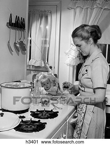 1950S Baby In Highchair Watching Mother In Kitchen At Stove Preparing Baby'S Milk Bottle View Large Photo Image Stock Image - 1950S Baby In Highchair Watching Mother In Kitchen At Stove Preparing Baby'S Milk Bottle. Fotosearch
