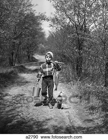 Stock Image - 1950S Boy Beagle Puppy Walking Down Country Road Whistling Carrying Fishing Pole Pail Fish. Fotosearch