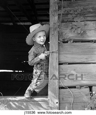 1950S Boy In Western Cowboy Outfit Holding Cap Gun Playing In Old Wooden Doorway View Large Photo Image Stock Photograph - 1950S Boy In Western Cowboy Outfit Holding Cap Gun Playing In Old Wooden Doorway. Fotosearch