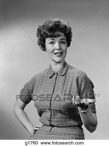 Stock Image - 1950S Brunette Woman Knit Dress Offhand Gesture Serious Expression. Fotosearch