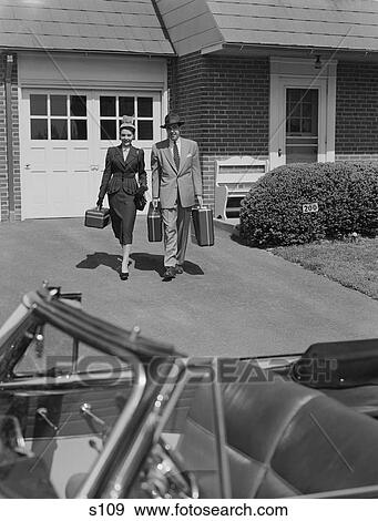 1950S Couple Carrying Luggage Walking Towards Convertible Car In Driveway View Large Photo Image Stock Photo - 1950S Couple Carrying Luggage Walking Towards Convertible Car In Driveway. Fotosearch