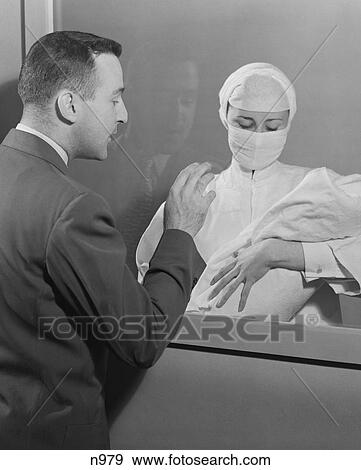 1950S Female Nurse Holding Infant Up To Father At Nursery Window View Large Photo Image Stock Photo - 1950S Female Nurse Holding Infant Up To Father At Nursery Window. Fotosearch
