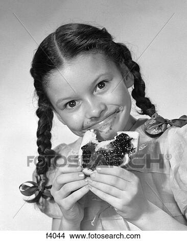 1950S Girl With Pigtails Eating Bread With Jelly Smeared On Her Face View Large Photo Image Picture - 1950S Girl With Pigtails Eating Bread With Jelly Smeared On Her Face. Fotosearch