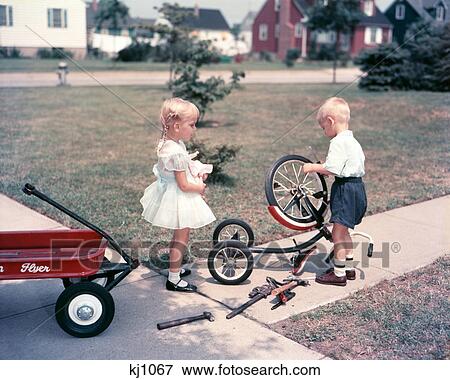 1950S Little Blonde Girl Sister Holding Doll Watching Little Boy Brother Repair Tricycle View Large Photo Image Stock Photo - 1950S Little Blonde Girl Sister Holding Doll Watching Little Boy Brother Repair Tricycle . Fotosearch