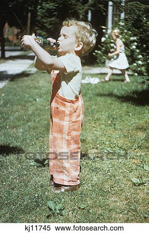 Download 1950s Little Boy Outside Drinking Soda From A 7up Bottle 1951 Stock Photography Kj11745 Fotosearch Yellowimages Mockups