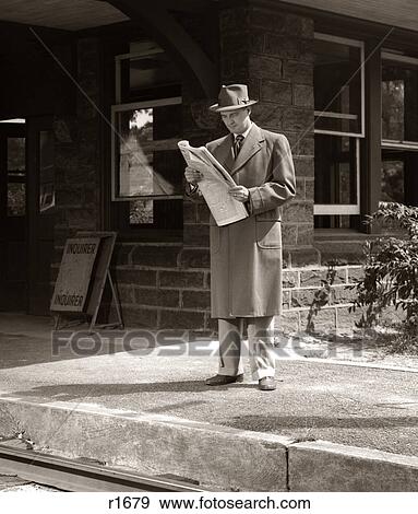 Stock Photo - 1950S Man Businessman Commuter On Railroad Station Platform Reading Newspaper Waiting For Train. Fotosearch