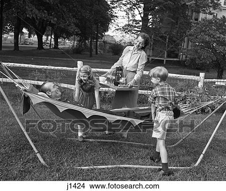Picture - 1950S Mom & Kids Serving Dad In Hammock. Fotosearch