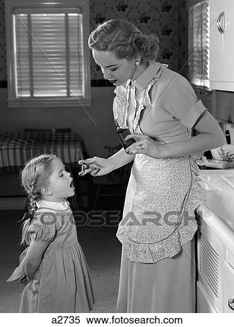 1950S Mother In Apron Giving A Spoonful Of Patent Medicine To Young Daughter In Kitchen View Large Photo Image Stock Photography - 1950S Mother In Apron Giving A Spoonful Of Patent Medicine To Young Daughter In Kitchen. Fotosearch