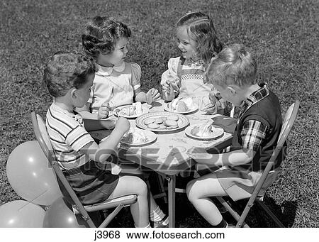 1950S Pair Of Boys & Girls At Table On Lawn Eating Cookies & Ice Cream For Birthday Party With Balloons At Side View Large Photo Image Stock Photo - 1950S Pair Of Boys & Girls At Table On Lawn Eating Cookies & Ice Cream For Birthday Party With Balloons At Side. Fotosearch