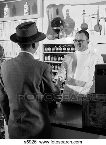 1950S Pharmacist Giving Prescription To Man Customer View Large Photo Image Stock Photograph - 1950S Pharmacist Giving Prescription To Man Customer. Fotosearch