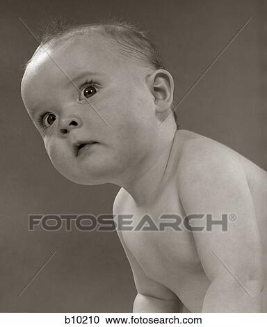 Stock Image - 1950S Portrait Baby Leaning To Side With A Wide-Eyed Expression. Fotosearch