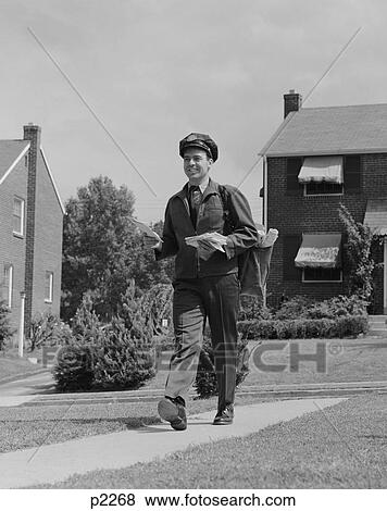 1950S Postal Mailman Walking Suburban Street Wearing Uniform Delivering Mail View Large Photo Image Stock Photo - 1950S Postal Mailman Walking Suburban Street Wearing Uniform Delivering Mail. Fotosearch