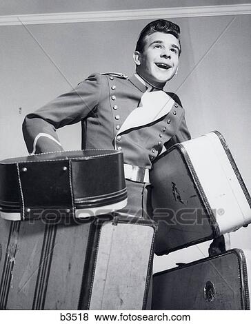 1950S Smiling Bellboy Carrying Four Bags Of Luggage View Large Photo Image Stock Photo - 1950S Smiling Bellboy Carrying Four Bags Of Luggage. Fotosearch