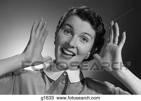 Stock Image - 1950S Smiling Happy Woman Holding Hands Up Beside Her Head. Fotosearch
